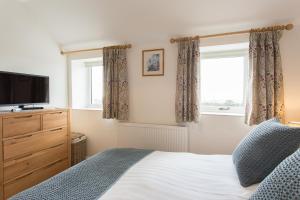 a bedroom with a bed and a tv and a window at Cornish Views in Camborne