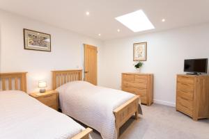 a bedroom with two beds and a flat screen tv at Cornish Views in Camborne