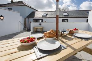 a table with plates and bowls of food on a deck at Cornish Views in Camborne