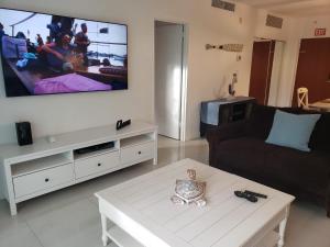 sala de estar con TV de pantalla plana grande en la pared en Stunning Beach Apartment by Miami Te Esperaa - HOLLYWOOD 3V, en Hollywood