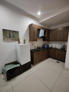 eine Küche mit Holzschränken und einem Kühlschrank in der Unterkunft 2 Bedrooms Standard Apartment Islamabad-HS Apartments in Islamabad