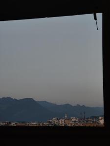 ein Fenster mit Blick auf die Berge und Gebäude in der Unterkunft 2 Bedrooms Standard Apartment Islamabad-HS Apartments in Islamabad