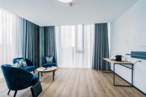 una habitación de hotel con 2 sillas y una mesa en YParc Hôtel, en Yverdon-les-Bains