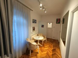 une chambre avec une table, des chaises et une fenêtre dans l'établissement Apartament Naturo, à Sibiu