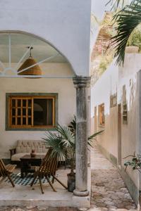an archway with chairs and a table in a house at Casa Mezcla - Bed & Breakfast in Mérida