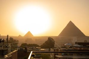 una vista sulle piramidi di Giza al tramonto di Sun and Sand Guest House a Il Cairo