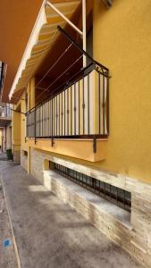 - un bâtiment jaune avec un balcon sur le côté dans l'établissement Vespucci Holiday, à Casteldaccia