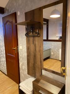 een kamer met een houten deur en een spiegel bij Hostel Homies Inn in Celiny