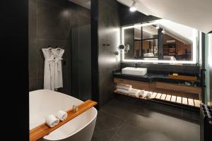 a bathroom with a tub and a sink and a mirror at Bavaria Sport Hotel in Gramado +54 photos