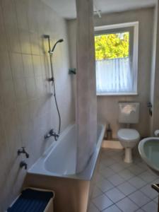 een badkamer met een bad, een toilet en een wastafel bij Monteurwohnung Kuhfelde in Kuhfelde