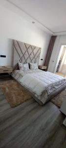 1 dormitorio con 1 cama grande y cabecero grande en Appartement 5 etoiles agadir vue mer, en Agadir