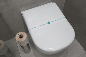 a white toilet in a bathroom with a roll of toilet paper at Capodichino Airport Home By Dimorra in Naples