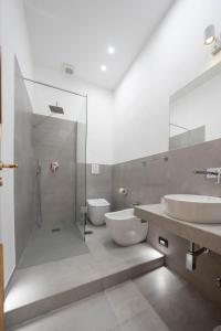 a bathroom with two sinks and a shower and a toilet at Capodichino Airport Home By Dimorra in Naples