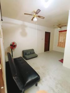 a living room with a couch and a ceiling fan at Casa Al Mare - Viajeros Booking Services in Gubat