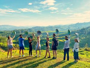 Un gruppo di persone che si trovano su una collina con le loro racchette di Sun Rice Homestay a Ruteng