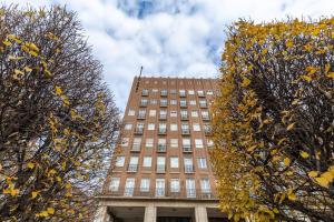 a tall brick building with trees in front of it at Midtown Artistic Apartment in Budapest