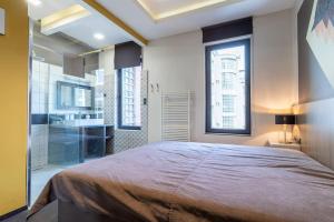 a bedroom with a large bed and a bathroom at Midtown Artistic Apartment in Budapest