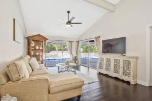 a living room with a couch and a flat screen tv at Naples Oasis in Naples
