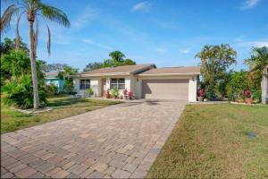 a house with a driveway and palm trees at Naples Oasis in Naples