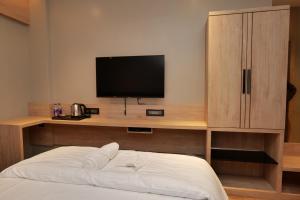 um quarto com uma cama e uma televisão numa secretária em V HOTEL em Brahmapur
