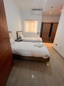 two beds in a room with a window at Vela in Is-Swieqi