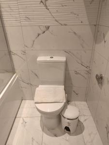 a bathroom with a toilet and a marble wall at Vela in Is-Swieqi
