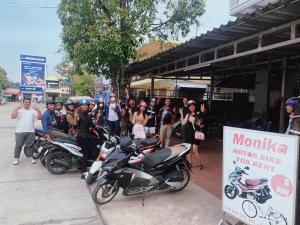 a group of people standing on a sidewalk next to motorcycles at KampongBay Makeng II Guesthouse in Kampot