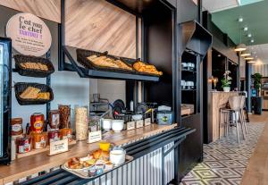 - une boulangerie avec du pain et des viennoiseries sur un comptoir dans l'établissement B&B HOTEL Besançon Valentin, à Besançon