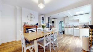 een keuken en eetkamer met een houten tafel en stoelen bij Charming 2-Bedroom Flat in the Heart of Cro London ER1 in South Norwood