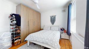 een slaapkamer met een bed en een kast bij Charming 2-Bedroom Flat in the Heart of Cro London ER1 in South Norwood