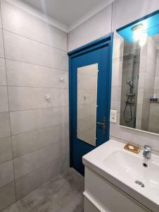 a bathroom with a sink and a blue door at Entre calanques et vieux port ! in La Ciotat