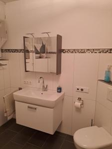 een witte badkamer met een toilet en een wastafel bij 7D Apartment mit 3 Schlafzimmern in Castrop-Rauxel