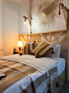 1 dormitorio con 1 cama grande y cabecero de madera en Paddle Out Morocco en Tamraght Ouzdar