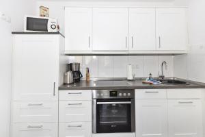cocina blanca con fregadero y microondas en Admiralsgarten, Steuerbord 12, en Duhnen