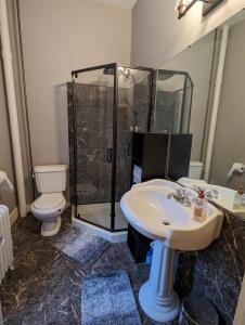 een badkamer met een douche, een wastafel en een toilet bij Historic Escape in Mansion Row - Sleeps 12! in New Albany