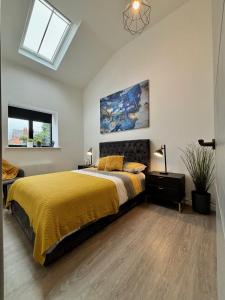 a bedroom with a bed with a yellow bedspread at Barn Conversion, Town Centre, Brand new, Beautiful designed, light, fresh and spacious, Secure parking option, Netflix TV ready, Wifi in Wellingborough