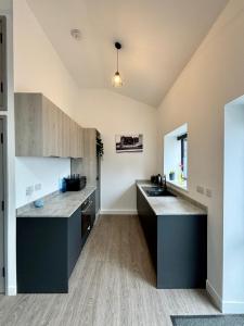 a large kitchen with a counter and a sink at Barn Conversion, Town Centre, Brand new, Beautiful designed, light, fresh and spacious, Secure parking option, Netflix TV ready, Wifi in Wellingborough