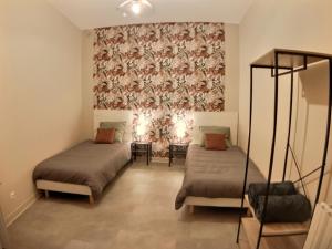 um quarto com 2 camas e um papel de parede floral em Myzenplace - Grand duplex cosy & chaleureux, situation idéale, parking em Montélimar