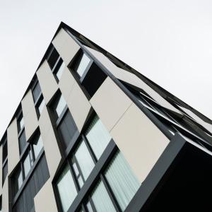 un grand bâtiment avec des fenêtres en verre dans l'établissement YParc Hôtel, à Yverdon-les-Bains