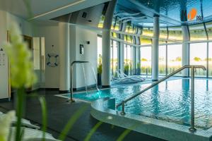 een groot zwembad in een gebouw met een zwembad bij Westin House Resort by MS Pro in Kołobrzeg