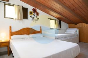 ein Schlafzimmer mit zwei Betten in einem Zimmer in der Unterkunft Mas de Felip - Casa rural con piscina privada en el Delta - Deltavacaciones in Riumar + 78 Fotos