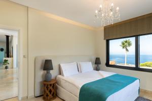 - une chambre avec un lit et une vue sur l'océan dans l'établissement Villa Jamila by Cura Villas Collection, à Kalathas