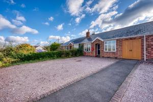 a brick house with a garage and a driveway at 2 Bedroom Bungalow with Garden and Parking 