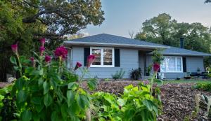 a house with flowers in the front yard at Art Haven: Immersive Art Stay in Denton