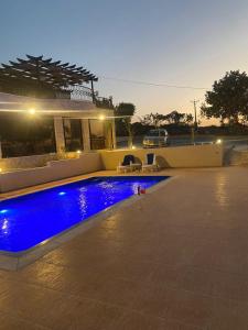 a swimming pool with blue lighting in front of a house at Amman landscape farm in Amman