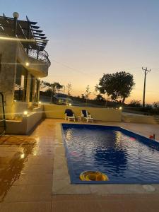 a swimming pool in front of a house at Amman landscape farm in Amman