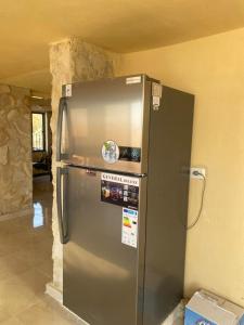 einen Kühlschrank aus Edelstahl in einem Zimmer mit einer Wand in der Unterkunft Amman landscape farm in Amman