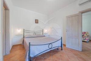 um quarto com uma cama azul num quarto branco em Casa Marida tra Cotoncello e Sant'Andrea - Goelba em SantʼAndrea