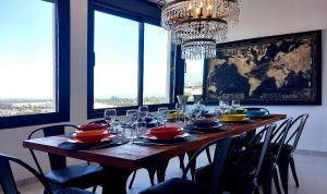 een eettafel met stoelen en een kroonluchter bij VillasRoyale Diamante in San Bartolomé