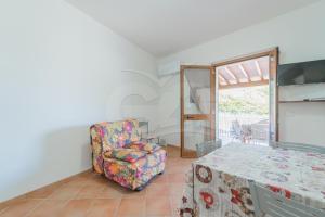 ein Wohnzimmer mit einem Stuhl und einem Tisch in der Unterkunft Casa Marida tra Cotoncello e Sant'Andrea - Goelba in SantʼAndrea